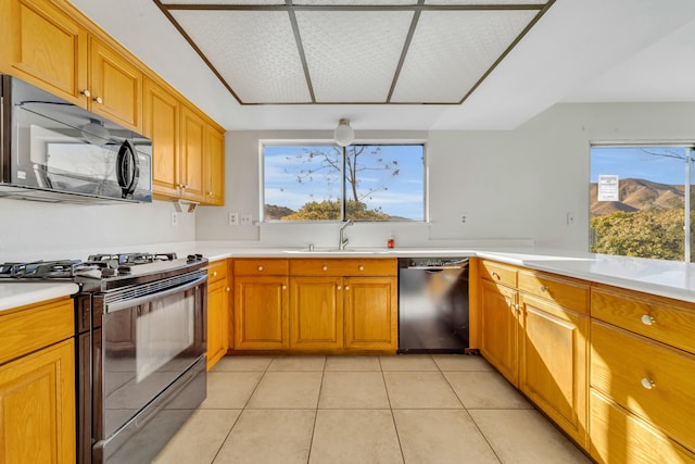 kitchen with black appliances, plenty of natural light, light tile patterned flooring, and sink