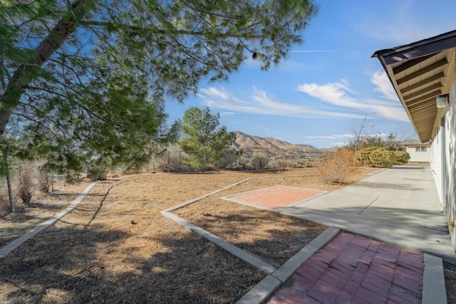 view of yard with a mountain view and a patio