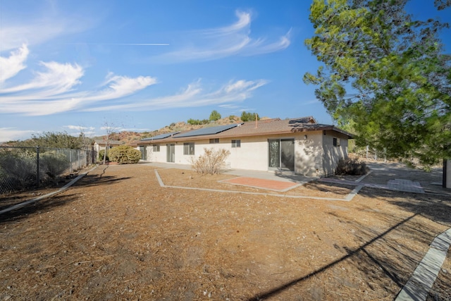 rear view of property featuring solar panels