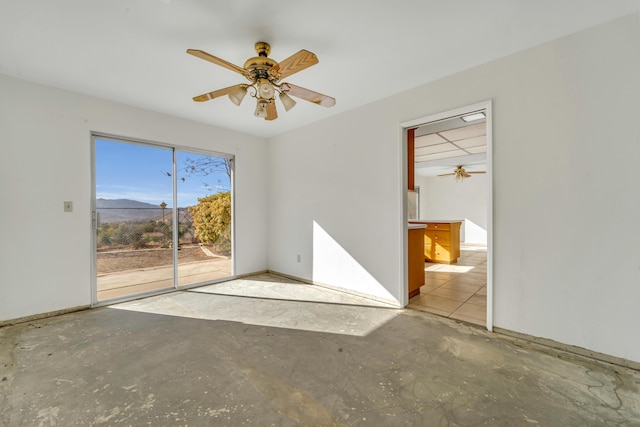 unfurnished room featuring a mountain view and ceiling fan