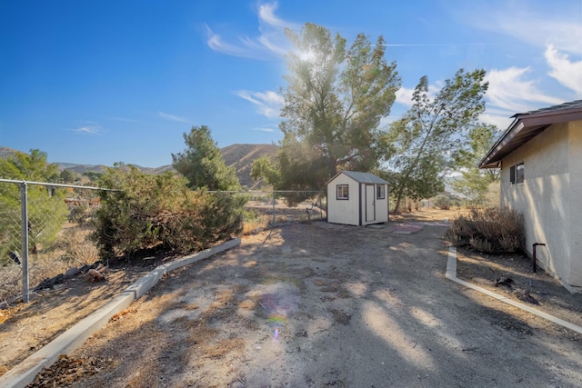 view of yard featuring a mountain view and a storage unit