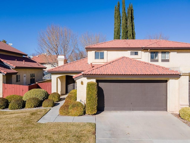 mediterranean / spanish-style house featuring a garage and a front lawn