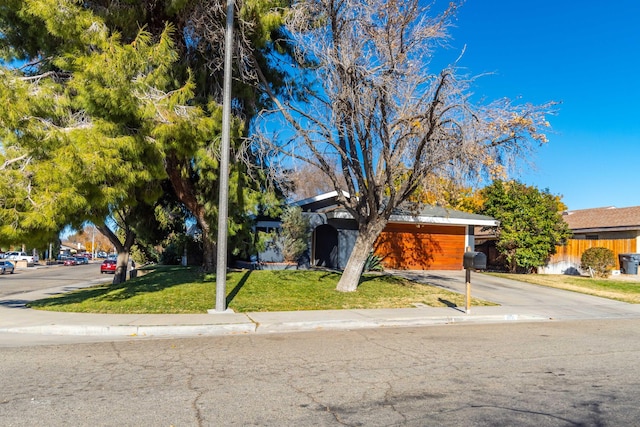 view of property hidden behind natural elements featuring a front yard