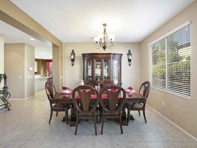 dining area with recessed lighting, an inviting chandelier, baseboards, a textured ceiling, and light tile patterned flooring