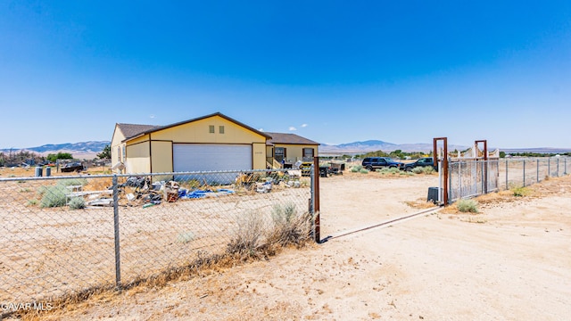 25739 Flatcreek St, Lancaster, CA 93536 - view of front of home with dirt driveway, a garage, and a mountain view