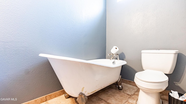 25739 Flatcreek St, Lancaster, CA 93536 - bathroom featuring a freestanding tub, baseboards, toilet, and tile patterned flooring