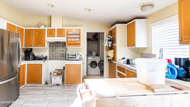 25739 Flatcreek St, Lancaster, CA 93536 - kitchen with freestanding refrigerator, washing machine and dryer, vaulted ceiling, and light countertops