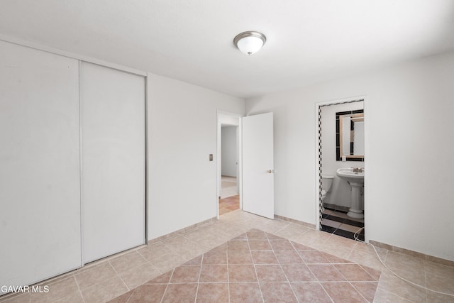 44338 W 23rd St, Lancaster, CA 93536 - unfurnished bedroom with light tile patterned floors, connected bathroom, and a closet