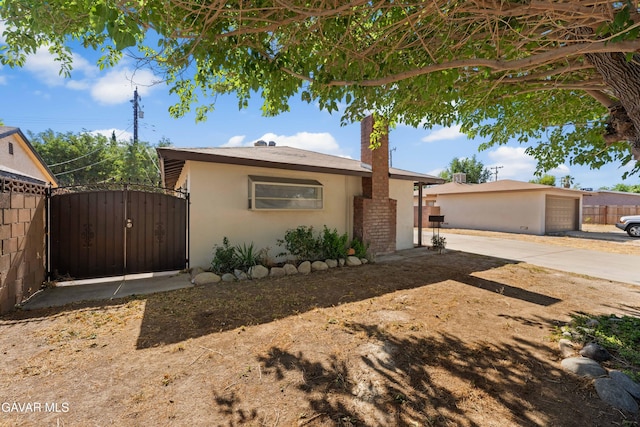 44338 W 23rd St, Lancaster, CA 93536 - view of front of house featuring stucco siding, driveway, and a gate