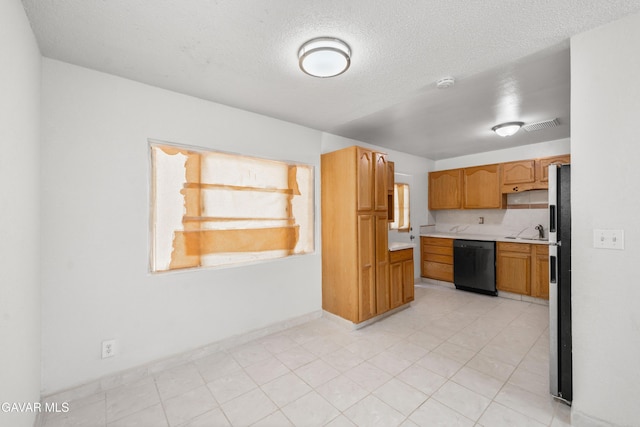 44338 W 23rd St, Lancaster, CA 93536 - kitchen featuring black dishwasher, light countertops, freestanding refrigerator, a textured ceiling, and brown cabinets