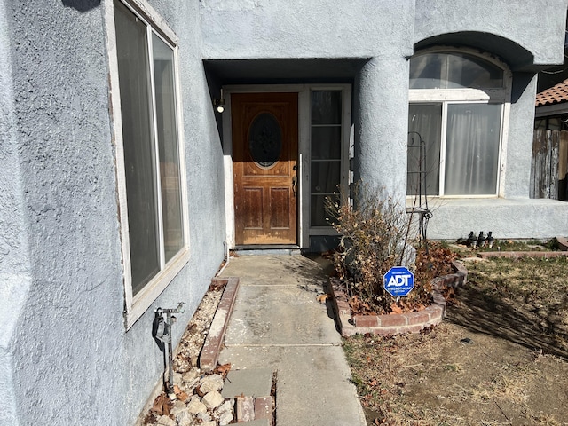 view of exterior entry with stucco siding