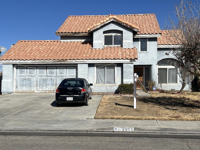 view of front of house with stucco siding, a garage, and a tile roof