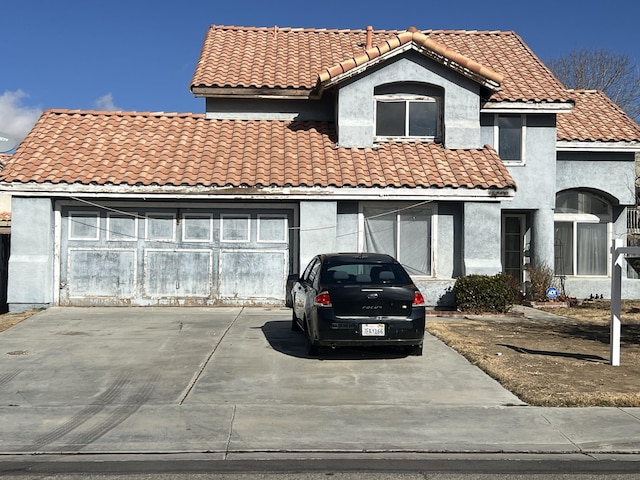 mediterranean / spanish-style home featuring stucco siding, a tile roof, and a garage