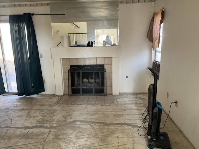 unfurnished living room featuring a tiled fireplace and wood finished floors