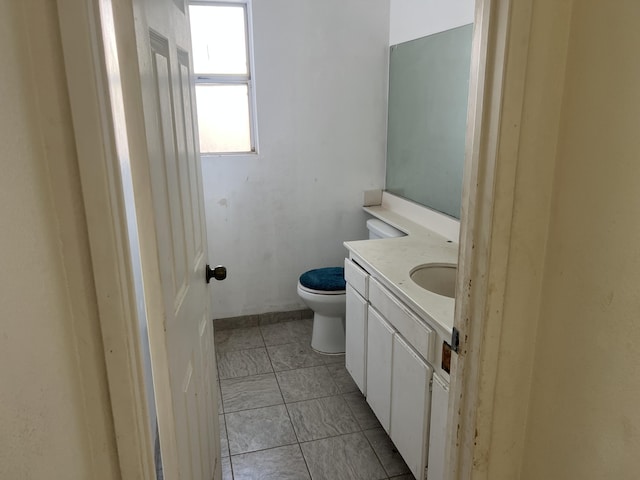 bathroom featuring tile patterned flooring, toilet, and vanity