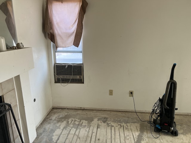 interior space featuring unfinished concrete floors, cooling unit, and baseboards