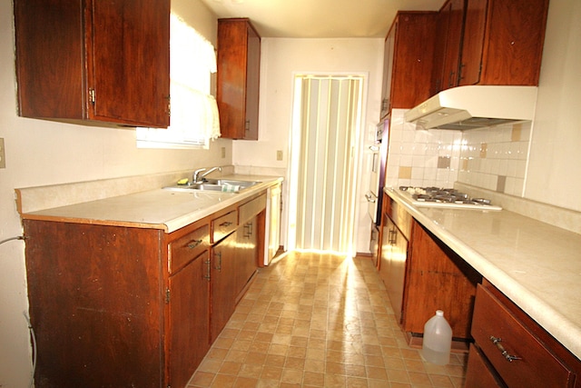 45581 Sancroft Ave, Lancaster, CA 93535 - kitchen featuring under cabinet range hood, white gas stovetop, a sink, backsplash, and light countertops