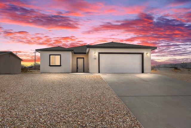 view of front facade with a garage, a shingled roof, concrete driveway, and stucco siding