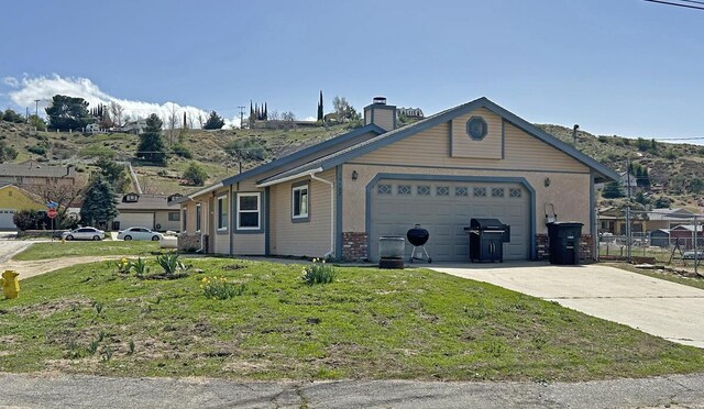 ranch-style house featuring fence, a chimney, a garage, a front yard, and driveway