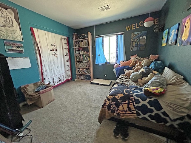 bedroom featuring carpet floors, a textured ceiling, and visible vents