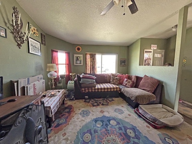 carpeted living area featuring a textured ceiling and a ceiling fan