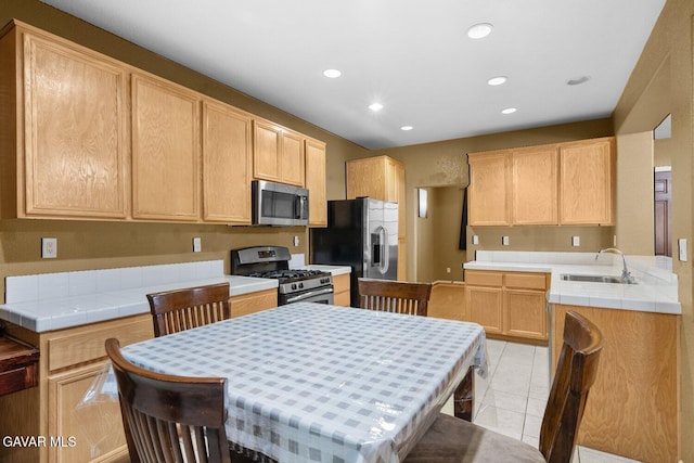 38160 Antibes Dr, Palmdale, CA 93552 - kitchen featuring appliances with stainless steel finishes, recessed lighting, light brown cabinets, light tile patterned flooring, and tile counters