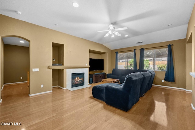38160 Antibes Dr, Palmdale, CA 93552 - living room featuring ceiling fan, light wood-style flooring, vaulted ceiling, a tiled fireplace, and arched walkways