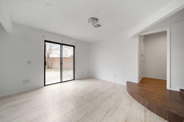 spare room with visible vents and a textured ceiling