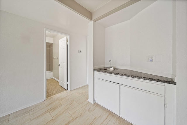 interior space with baseboards and a sink