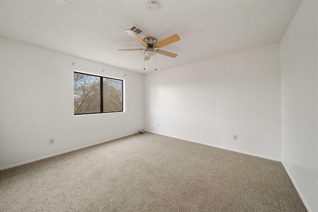 carpeted empty room featuring a textured ceiling, baseboards, visible vents, and ceiling fan