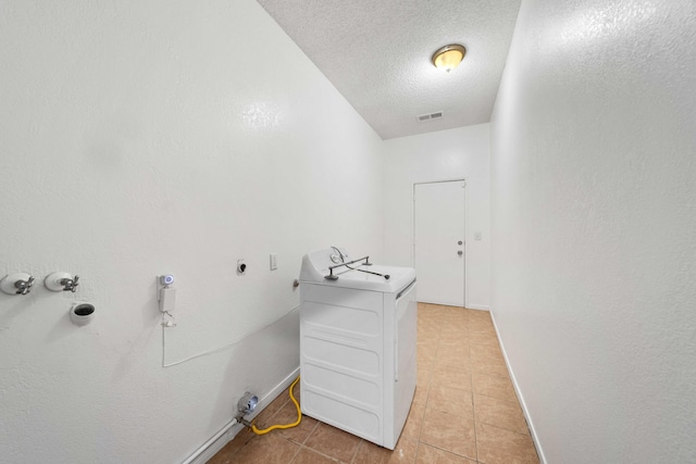 washroom featuring visible vents, baseboards, light tile patterned floors, laundry area, and a textured ceiling