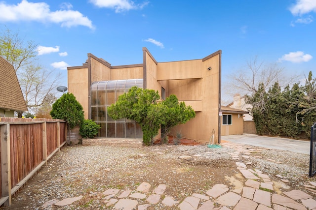 view of home's exterior with a patio area and fence