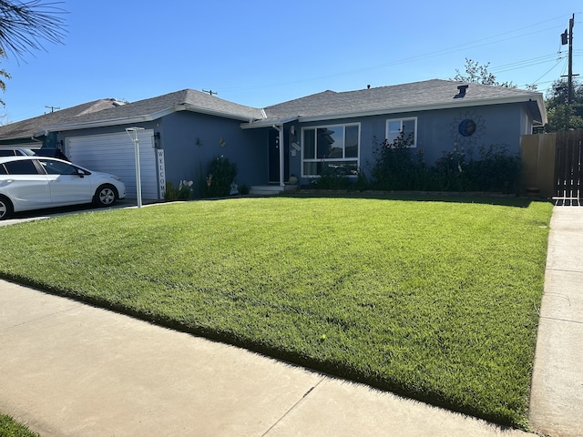 ranch-style house featuring a garage and a front lawn