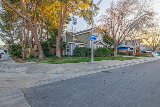 view of front of home with a residential view and fence