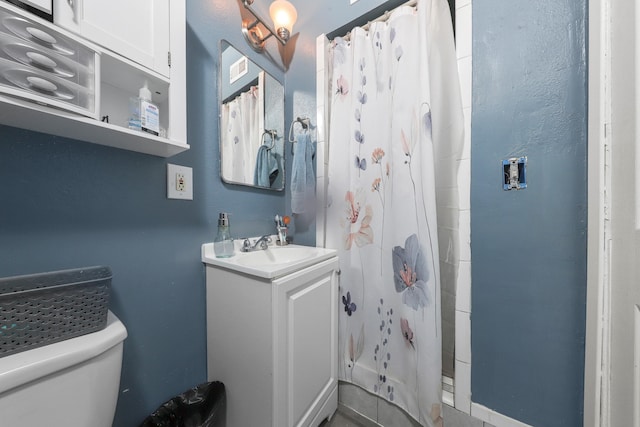 bathroom featuring toilet, vanity, and a shower with curtain