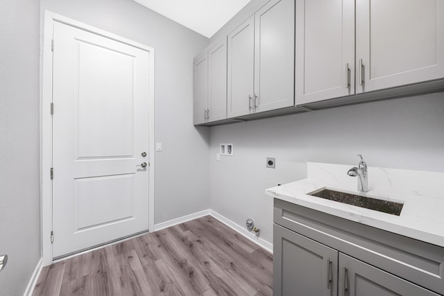 laundry area featuring washer hookup, sink, cabinets, light hardwood / wood-style floors, and electric dryer hookup