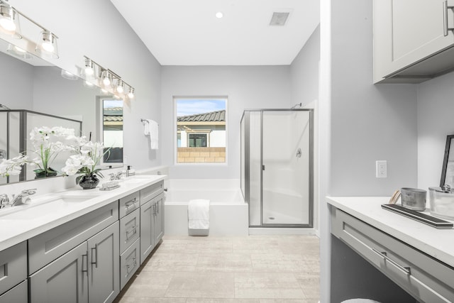 bathroom with vanity and shower with separate bathtub