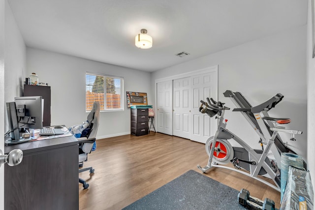 office area featuring visible vents, baseboards, and wood finished floors