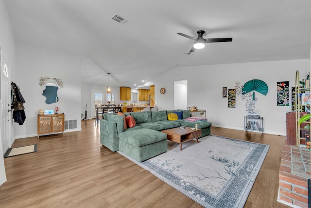 living area with lofted ceiling, ceiling fan, light wood-style flooring, and visible vents