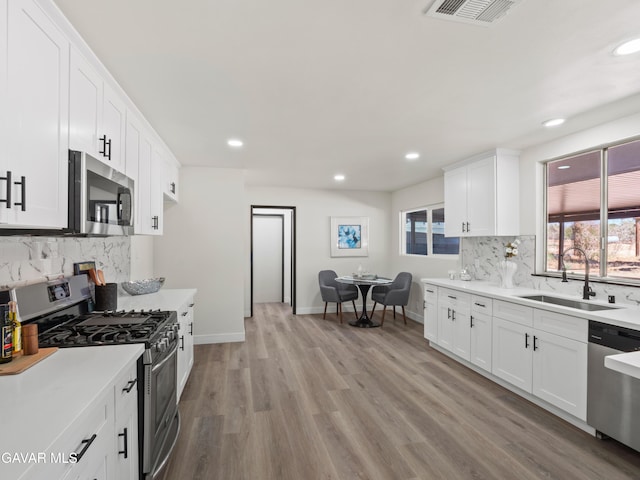 2350 W W Ave N Unit 12, Palmdale, CA 93551 - kitchen featuring appliances with stainless steel finishes, recessed lighting, decorative backsplash, white cabinets, and light countertops