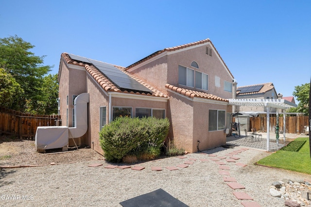 38030 Lido Dr, Palmdale, CA 93552 - rear view of property with a pergola, roof mounted solar panels, stucco siding, and a tiled roof