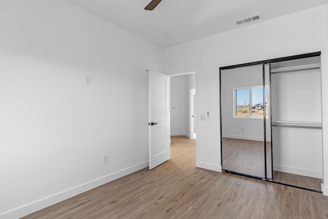 unfurnished bedroom featuring light wood finished floors, visible vents, a closet, and baseboards