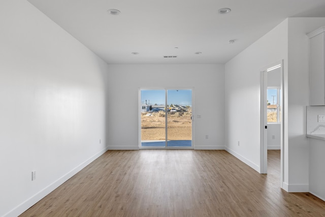 empty room featuring visible vents, recessed lighting, baseboards, and wood finished floors