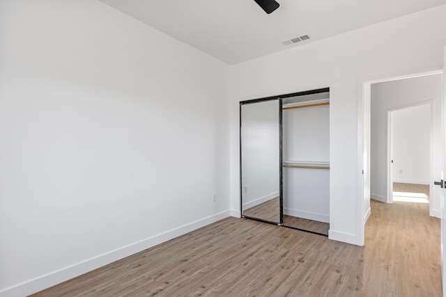 unfurnished bedroom with visible vents, baseboards, a closet, and light wood-style flooring