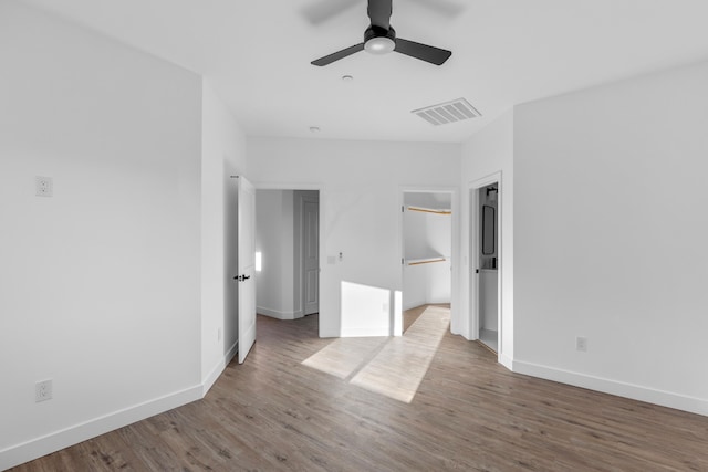 unfurnished bedroom featuring visible vents, a ceiling fan, baseboards, and wood finished floors