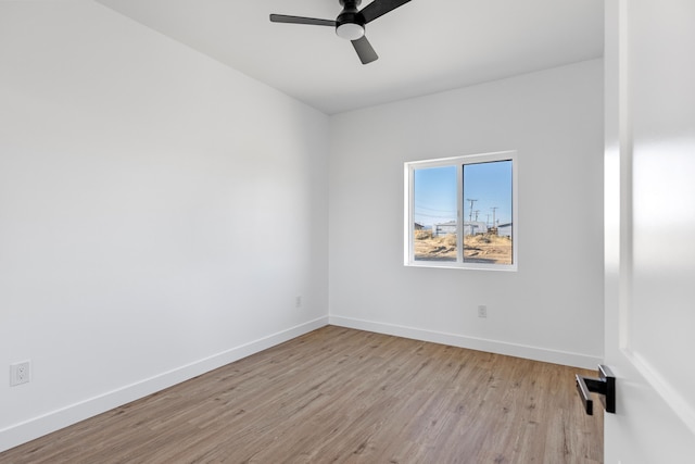 spare room featuring ceiling fan, baseboards, and wood finished floors