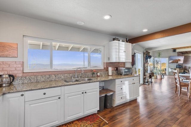 23761 El Rancho Dr, Tehachapi, CA 93561 - kitchen with a sink, dark wood finished floors, white cabinetry, beam ceiling, and tasteful backsplash