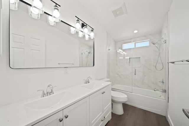 full bathroom with shower / bath combination with glass door, vanity, wood-type flooring, and toilet