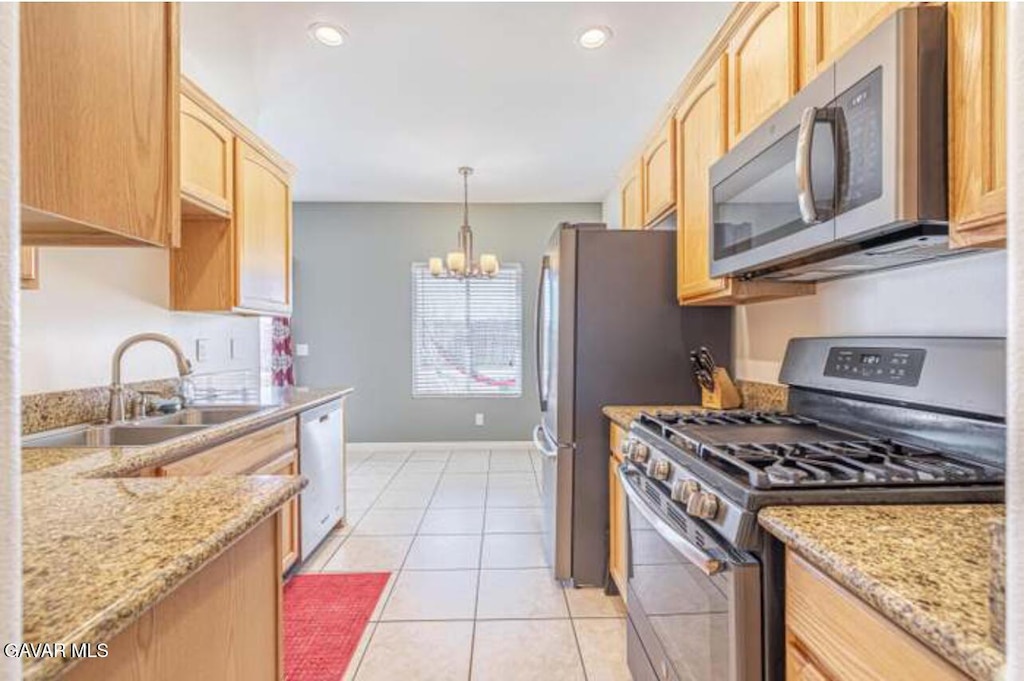 8400 Dogwood Ave, California City, CA 93505 - kitchen featuring stainless steel appliances, light brown cabinets, a chandelier, light stone counters, and light tile patterned floors