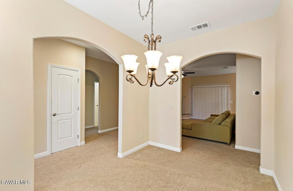 8400 Dogwood Ave, California City, CA 93505 - unfurnished dining area with arched walkways, a chandelier, and light carpet